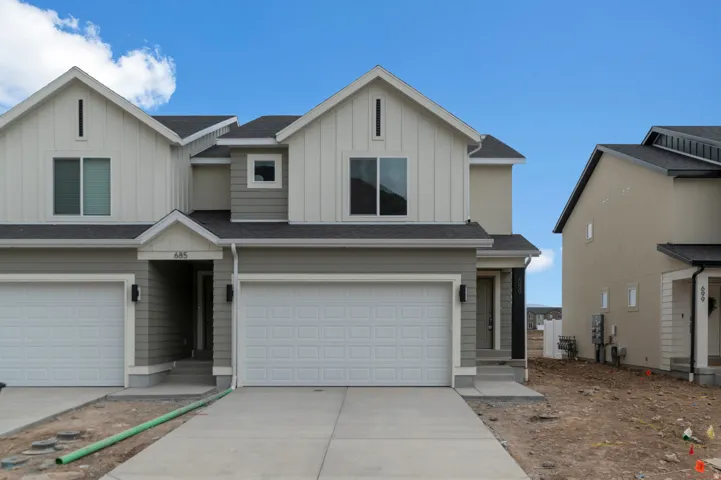 Modern townhome featuring a two-tone exterior with vertical siding accents and a contrasting roofline
