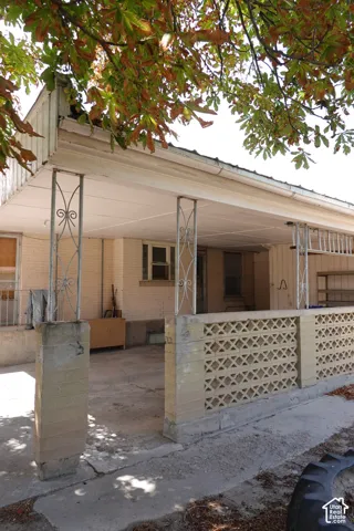 Covered patio with decorative metal columns and concrete block wall featuring geometric cutouts