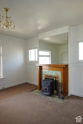 Fireplace with a natural wood mantel, decorative tile surround, and a cast iron stove insert