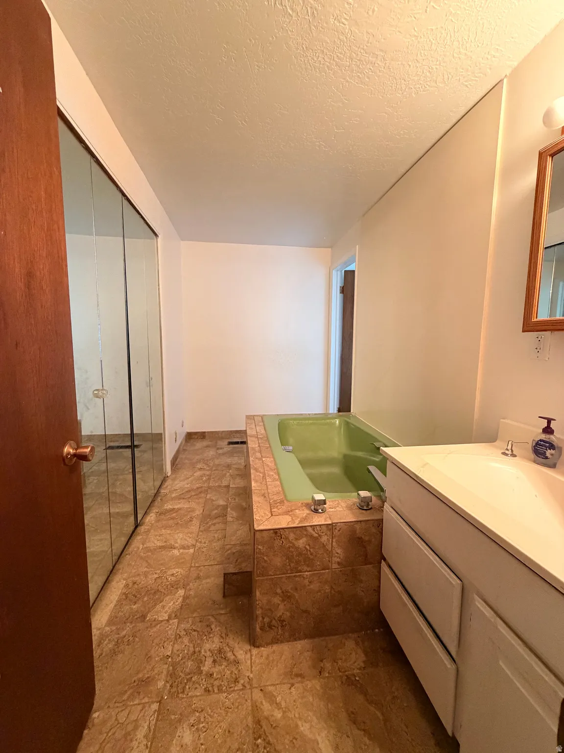 Tiled flooring complementing a built-in soaking tub with a tiled surround