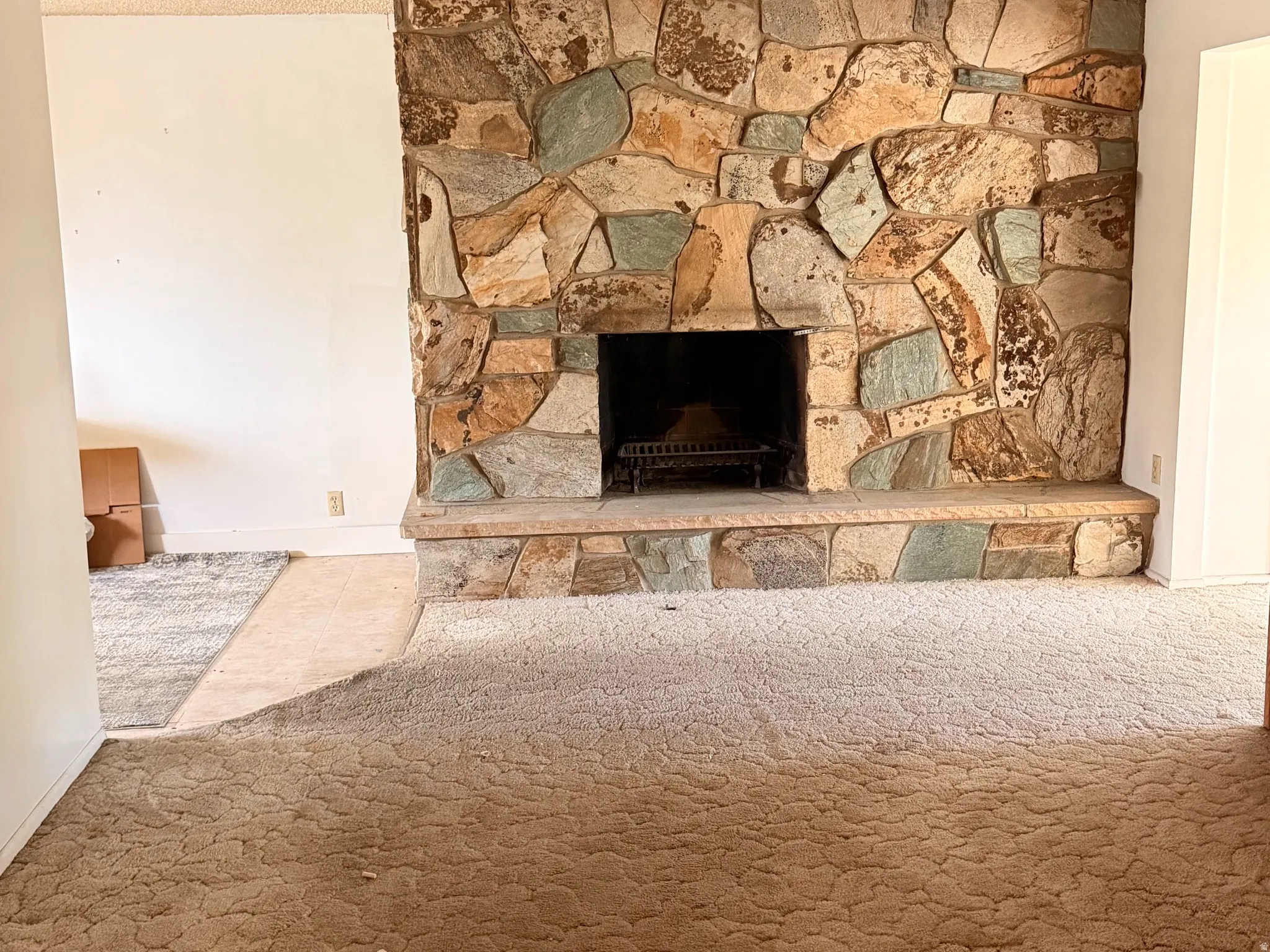 Expansive stone fireplace featuring a hearth and integrated firebox