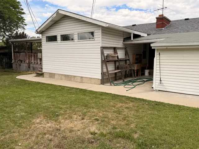 White vinyl siding exterior with an attached covered porch and a concrete patio