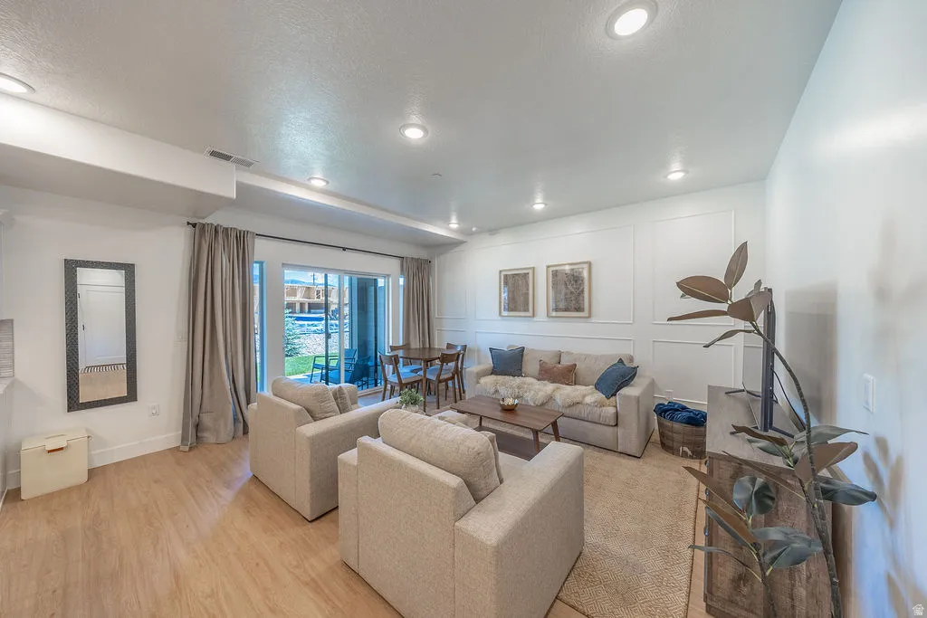 Living room with sliding door to back patio with seating and hot tub.