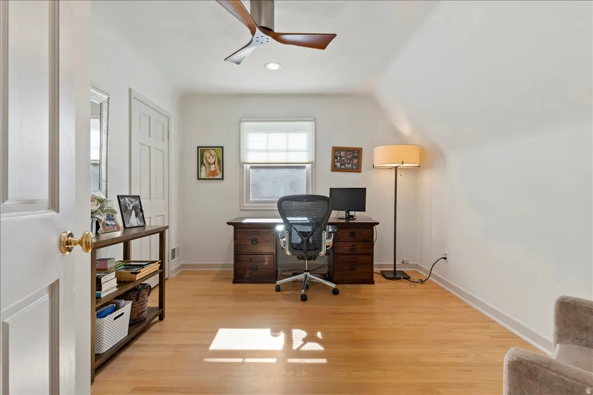 Room featuring light wood-finish flooring, white walls, and a window with blinds