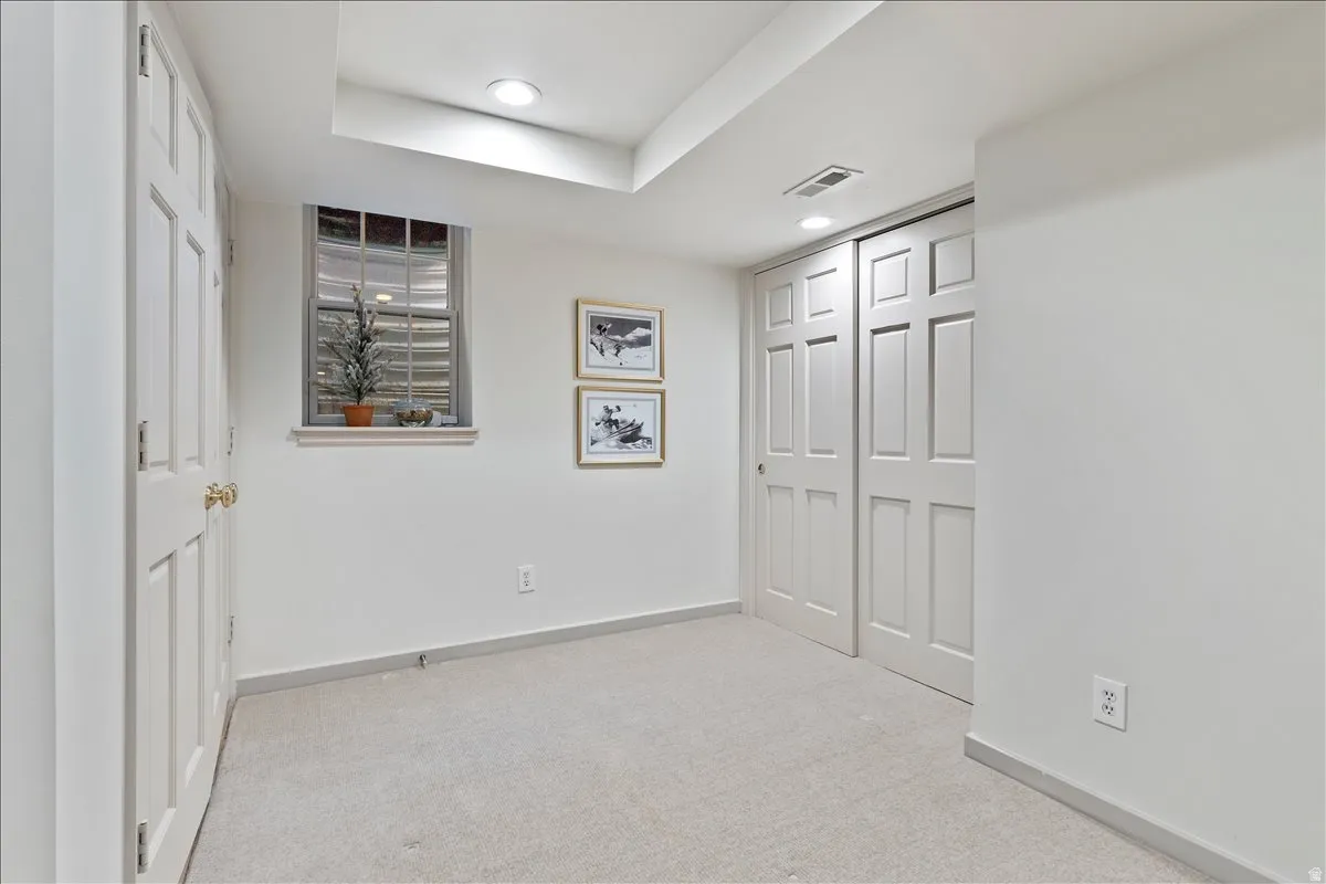 Carpeted room featuring a double-pane window, recessed lighting, white six-panel door, and a two-panel sliding closet door