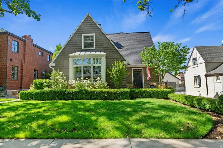 Shingled exterior with a prominent bay window, dormer, and dark roof