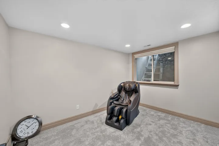 Carpeted room featuring recessed lighting, a window with wood trim, and neutral-toned walls