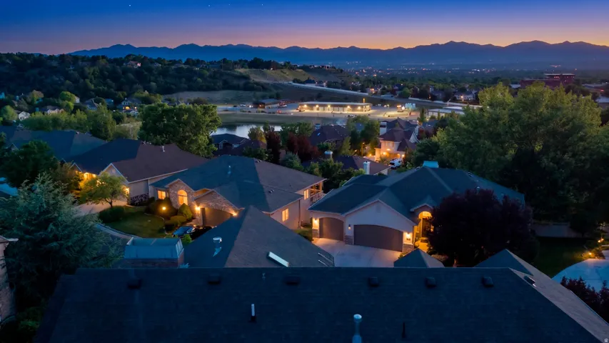 Aerial perspective showcasing a residential neighborhood with distant mountain ranges and a body of water