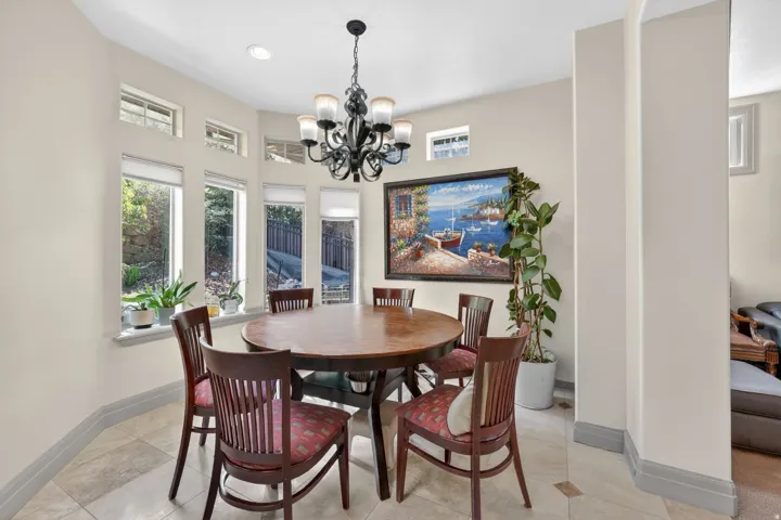 Dining area with a multi-pane bay window, recessed lighting, and a decorative chandelier