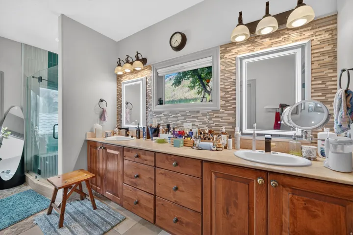 Double vanity featuring wood cabinetry, integrated sinks, and light countertops