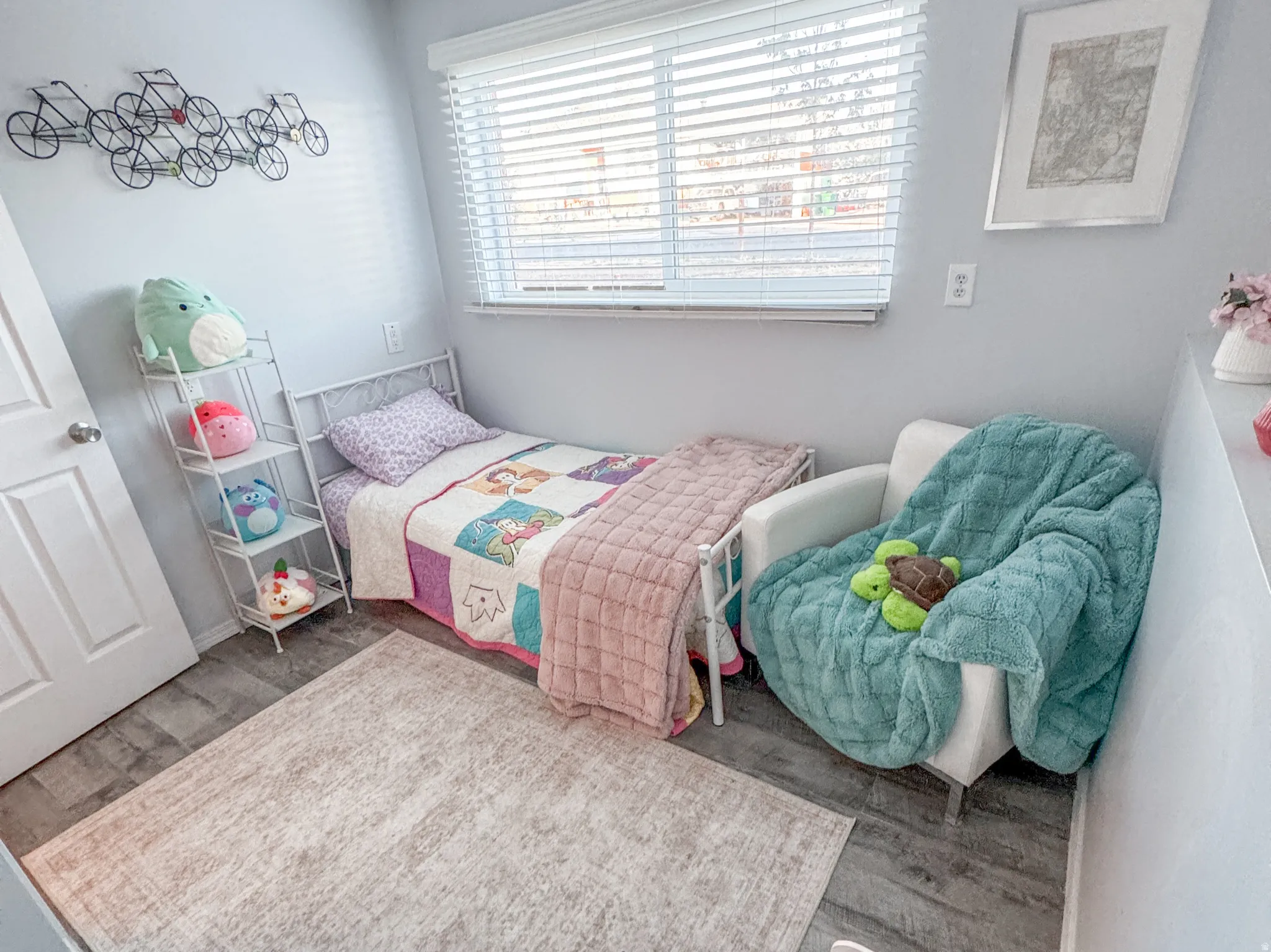 Room featuring a window with white blinds, wood-finish flooring, and light-colored walls