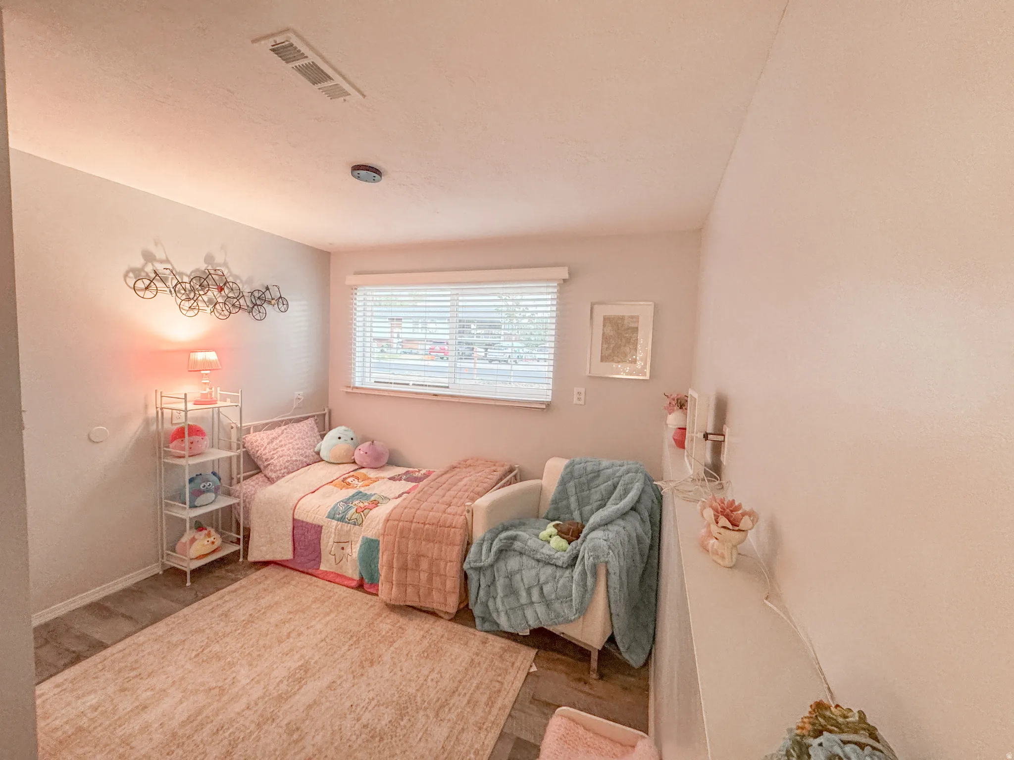 Room featuring wood-finish flooring, a window with blinds, a ceiling light fixture, and an HVAC vent