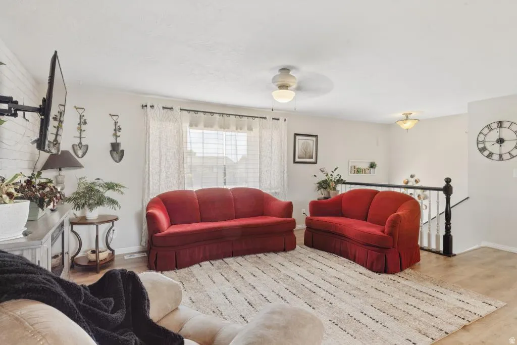 Living area featuring light wood-finish flooring, white walls, and a ceiling-mounted light fixture