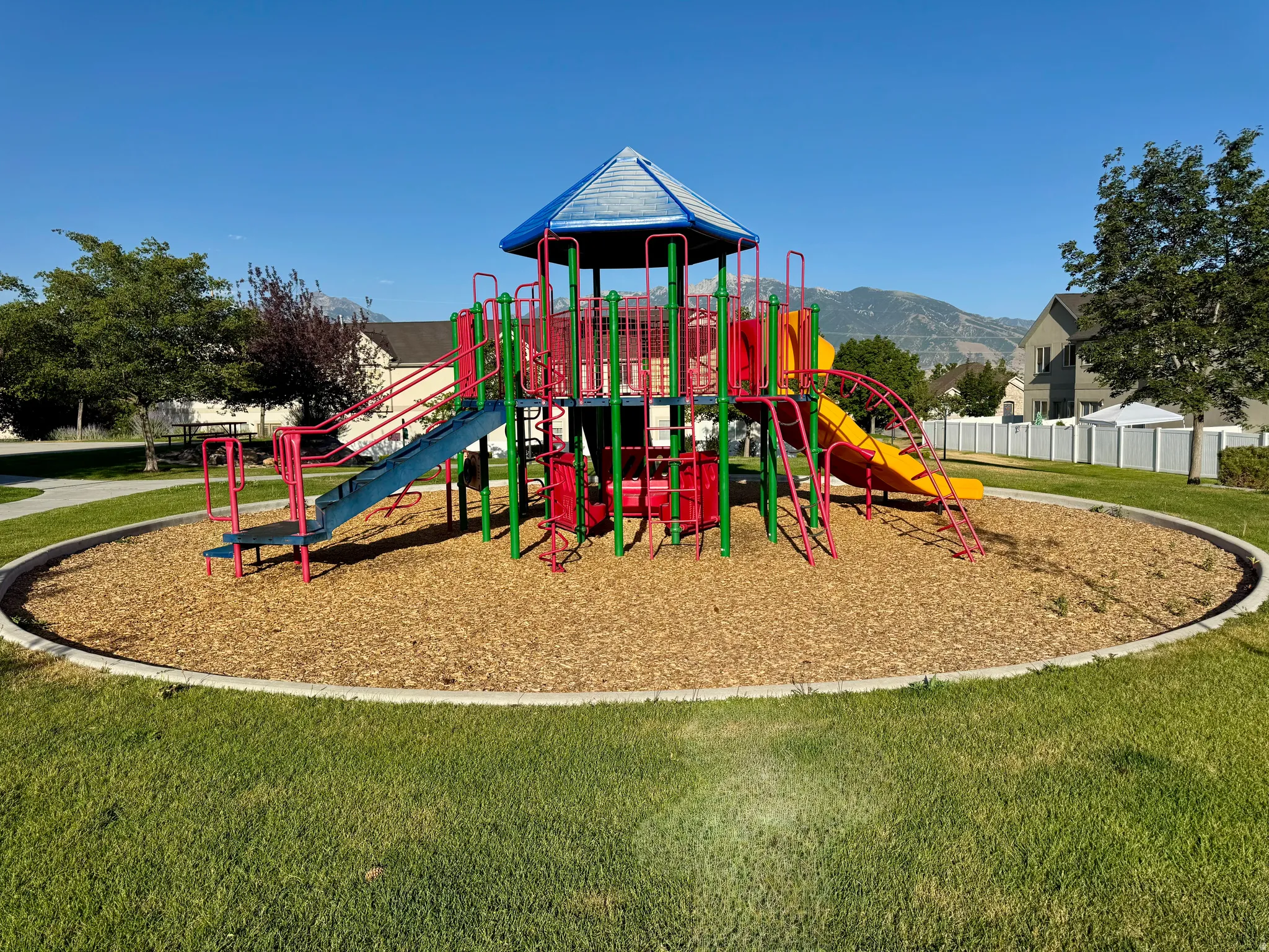 Community playground featuring a multi-level play structure with slides and climbing elements