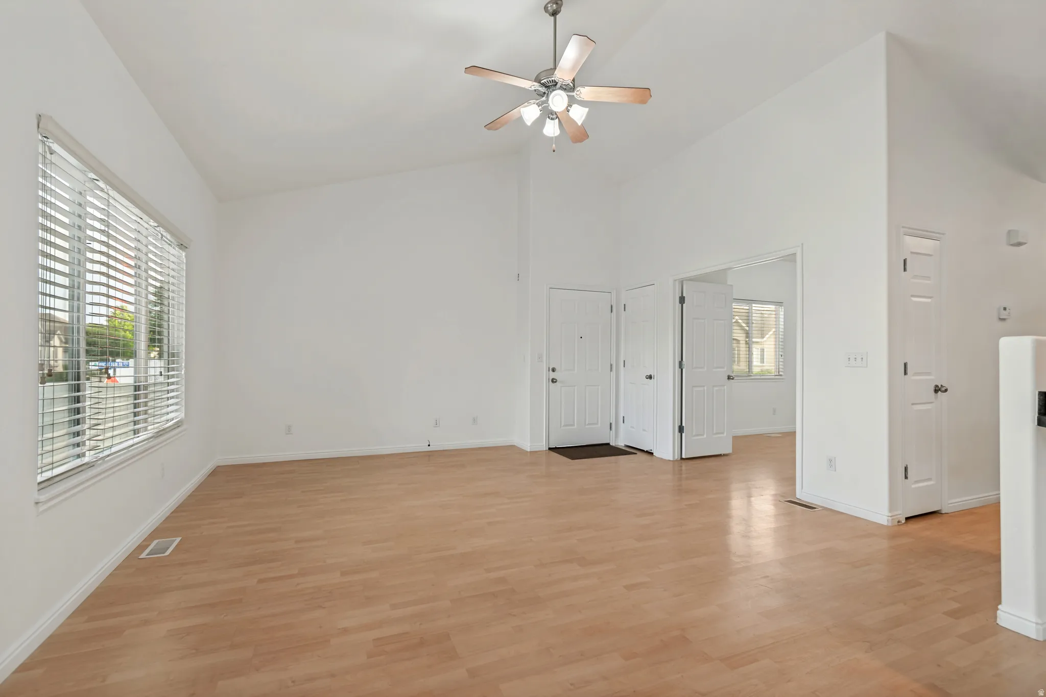 Spacious interior featuring vaulted ceilings and wood-finish flooring