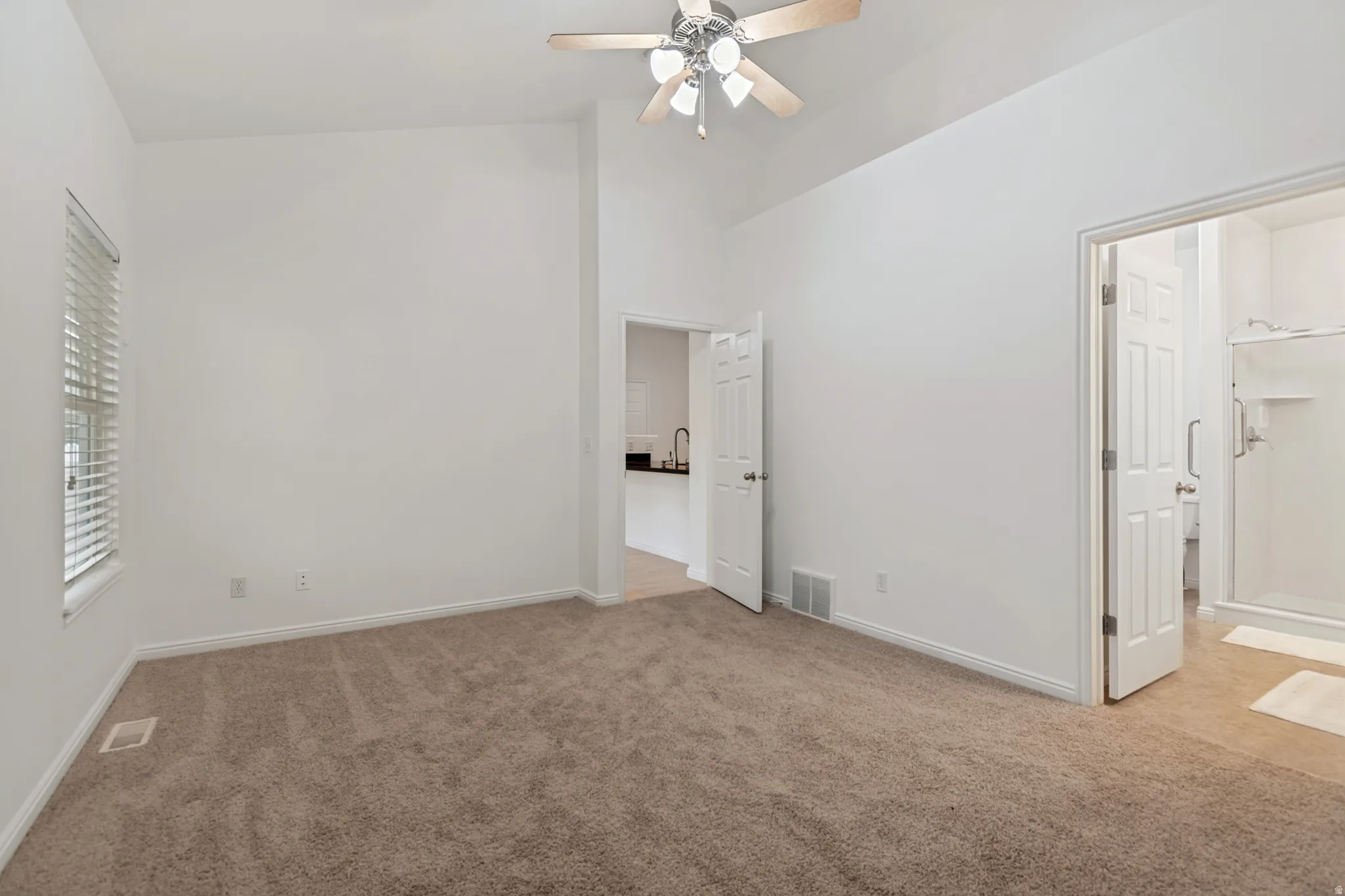 Primary bedroom with vaulted ceiling and new carpet