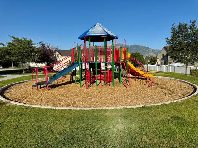 Community playground featuring a multi-level play structure with slides and climbing elements