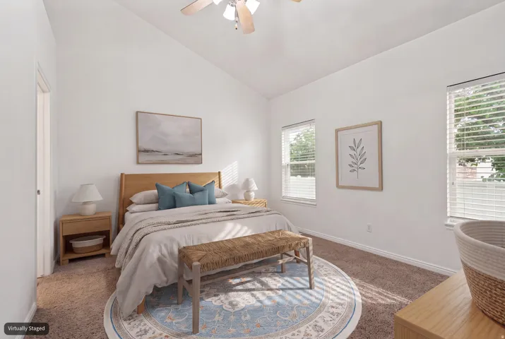 Primary bedroom with vaulted ceiling and new carpet (virtually staged)