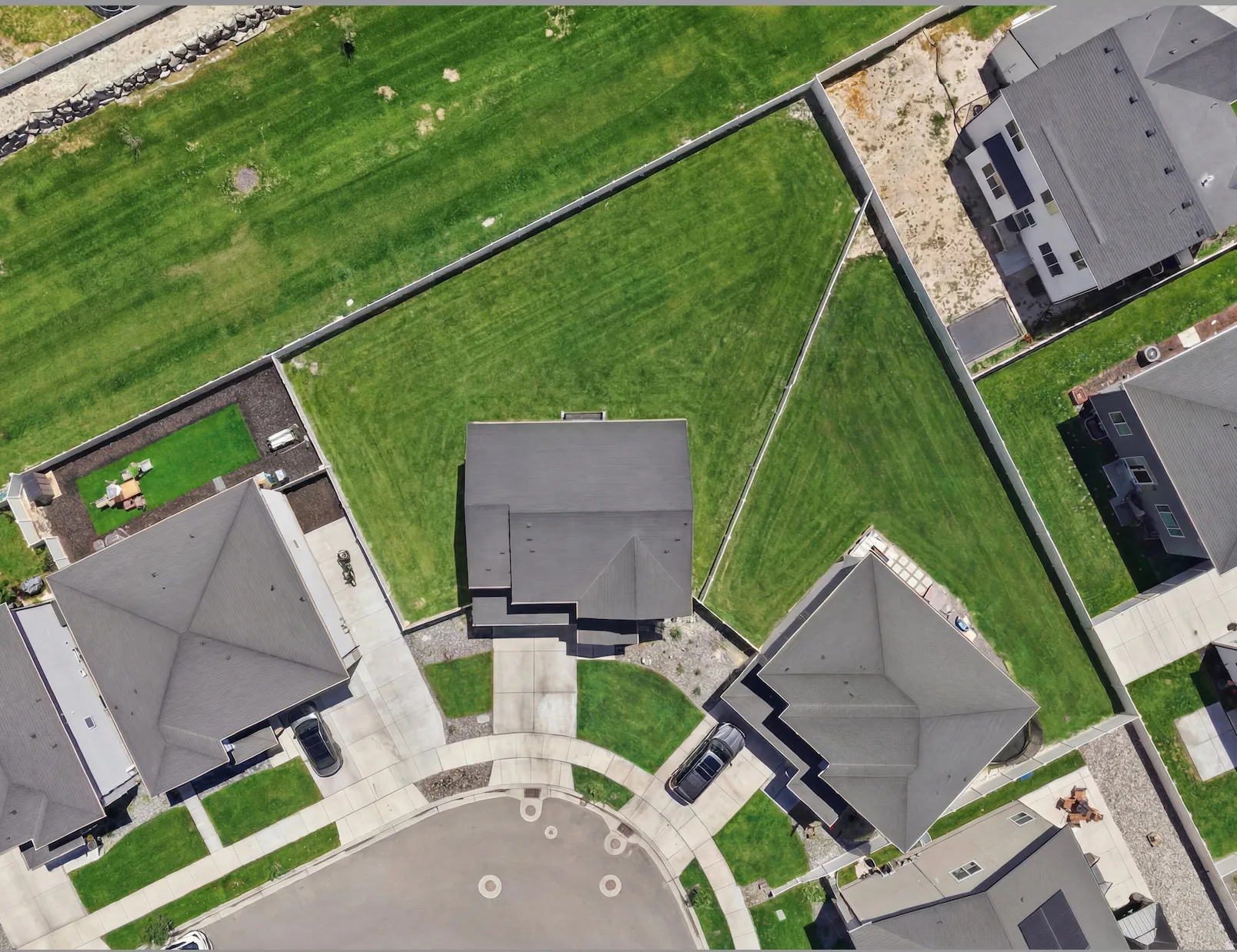 Expansive property featuring a cul-de-sac location, concrete driveway, and a large, fenced grass yard. Digitally enhanced to illustrate landscaping option.