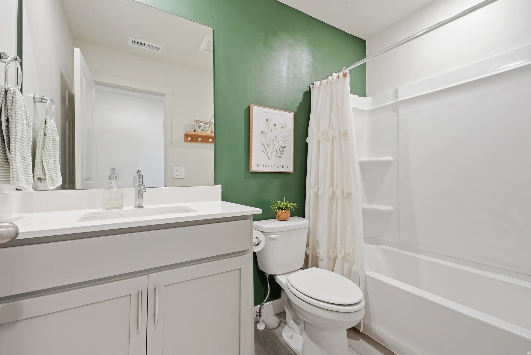 Bathroom featuring a white vanity with an integrated sink and light gray cabinetry