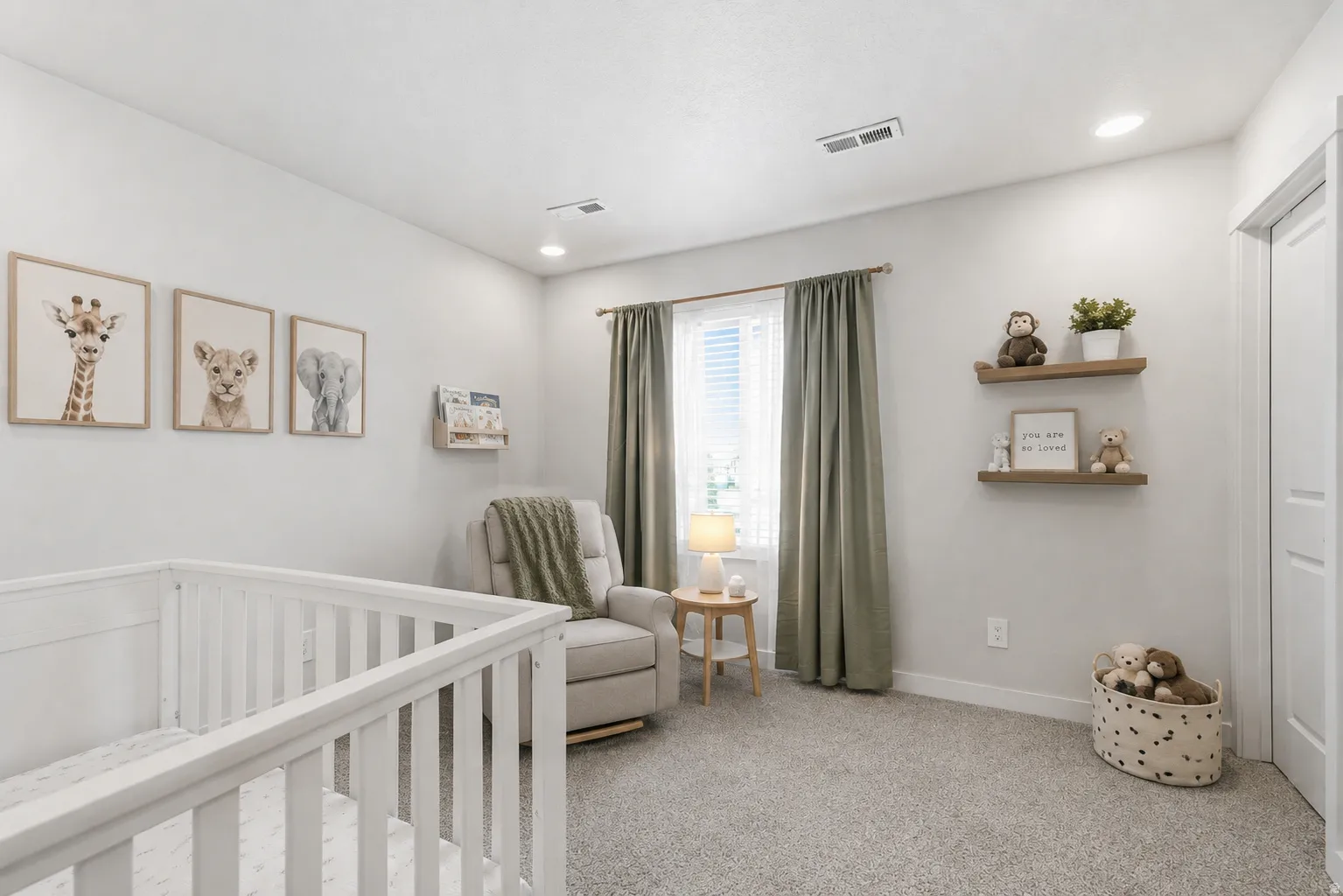 Well-lit room featuring light gray walls and plush gray carpeting