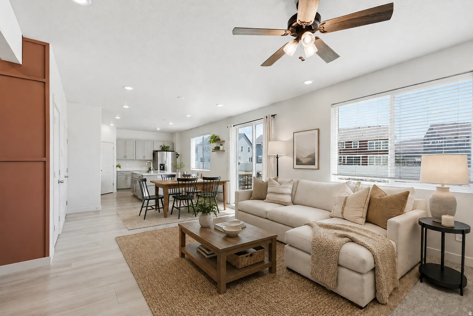 Open-concept living area featuring light wood-finish flooring, recessed lighting, and a ceiling fan