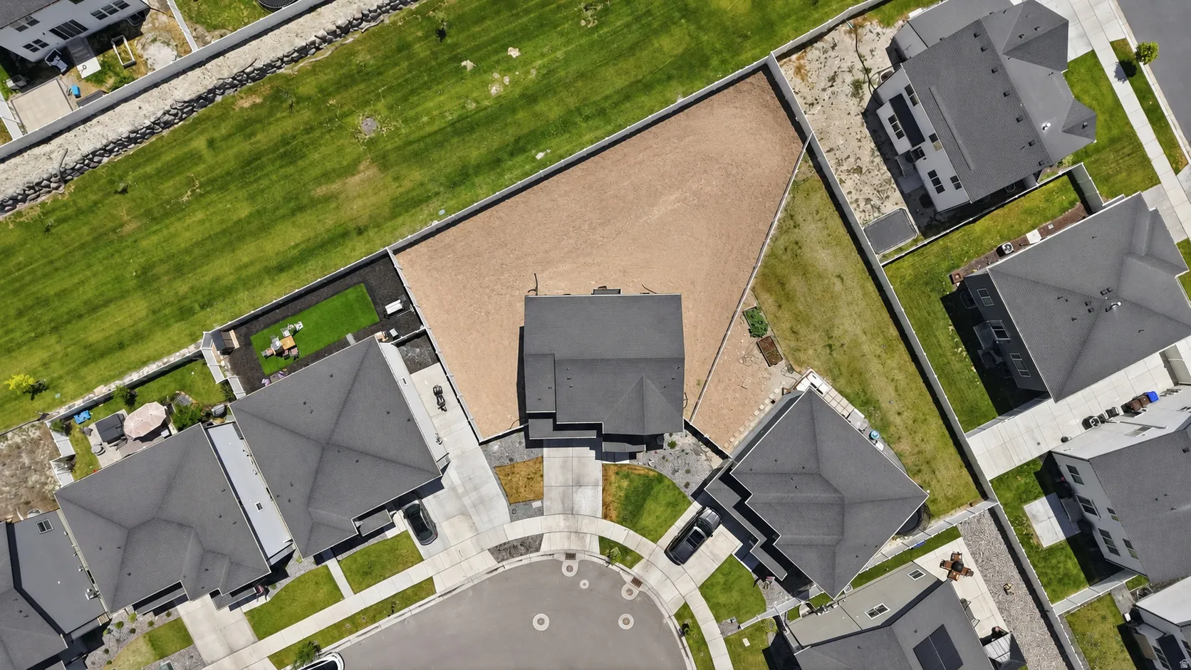 Spacious property featuring a large gravel-filled yard, a cul-de-sac entrance, and a paved driveway