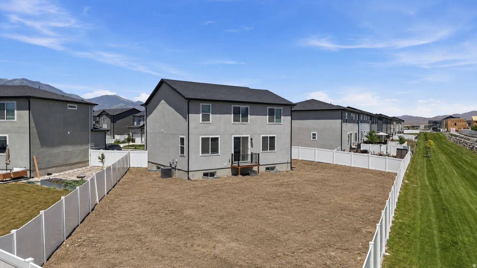 Contemporary gray stucco exterior with a dark shingle roof