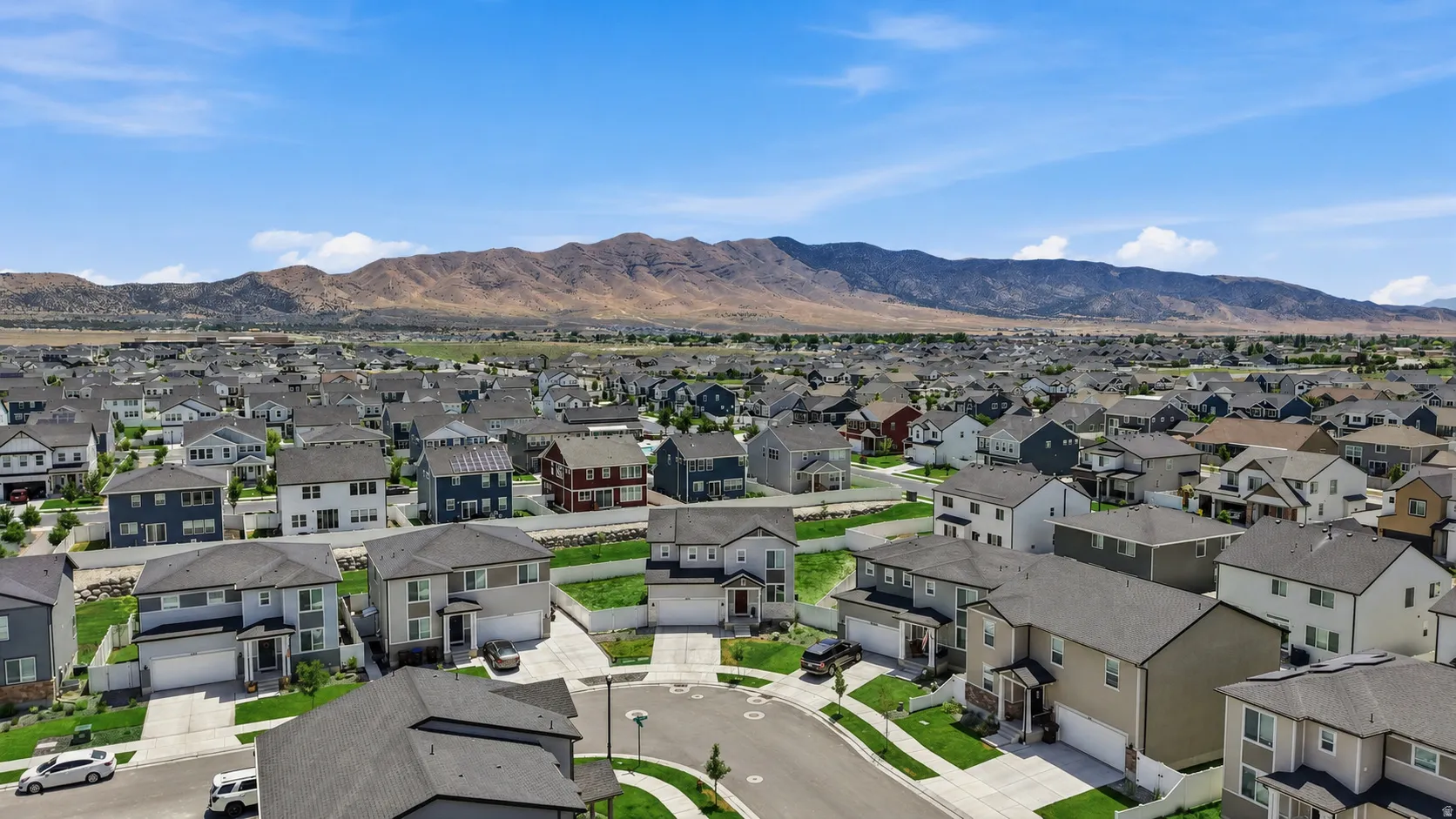 Residential community featuring a variety of single-family homes with mountain backdrops. Digitally enhanced to illustrate landscaping option.