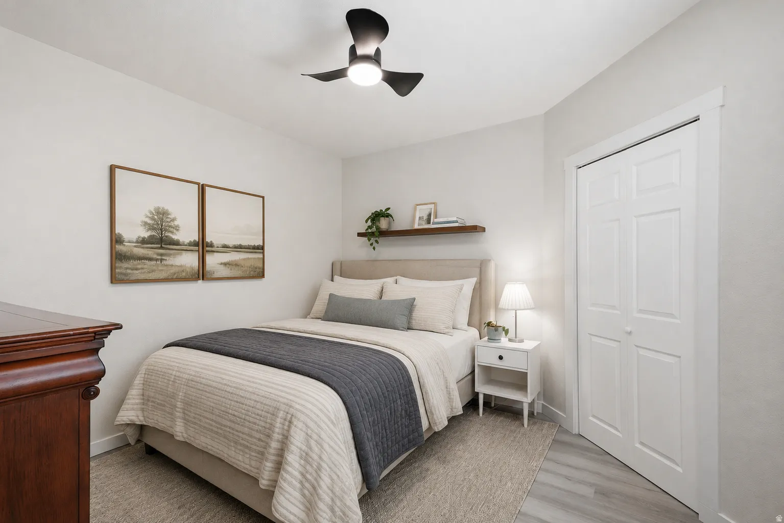 Bedroom featuring light gray wood-finish flooring, white walls, and a ceiling fan with integrated lighting