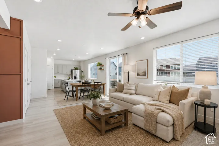 Open-concept living area featuring light wood-finish flooring, recessed lighting, and a ceiling fan