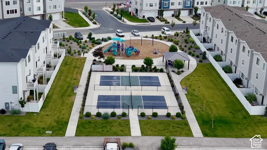 Community amenities including two fenced pickleball courts, a covered pavilion, and a central playground with a soft-surface area