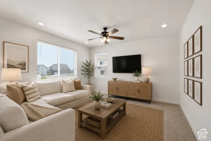 Spacious living area featuring large windows with horizontal blinds, recessed lighting, and a ceiling fan