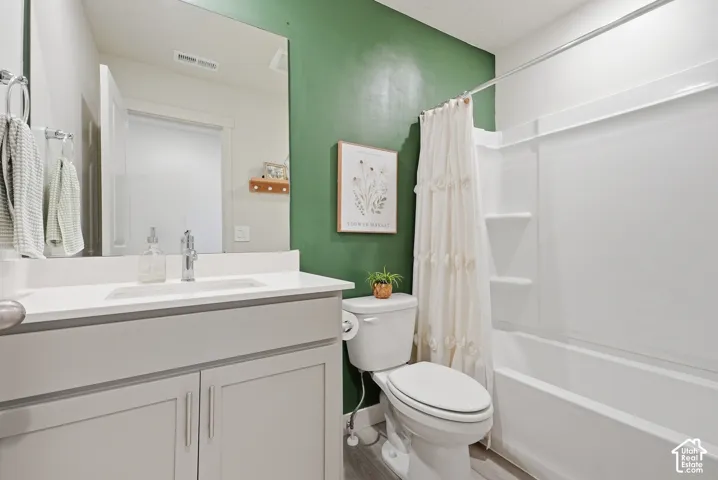 Bathroom featuring a white vanity with an integrated sink and light gray cabinetry