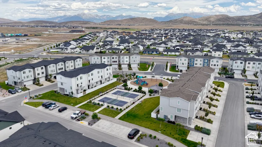 Expansive community featuring multi-story townhomes with dark gray roofs and light-toned siding