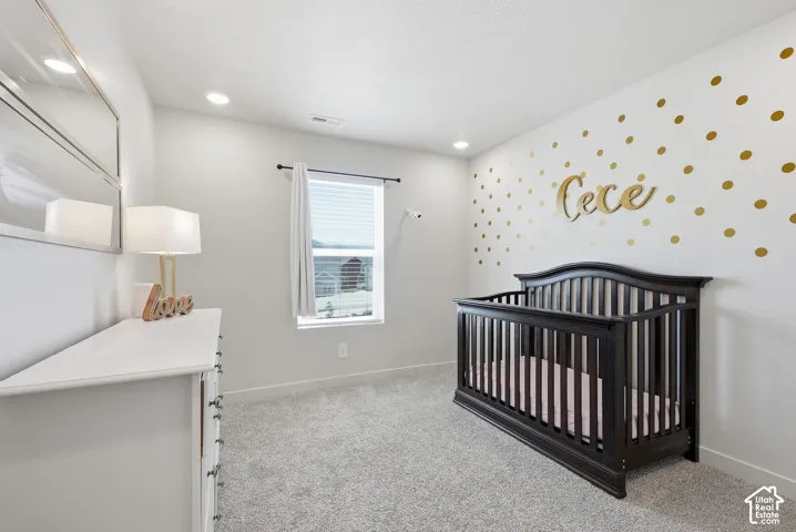 Carpeted interior space featuring recessed lighting, a white painted wall, a window with horizontal blinds, and base molding