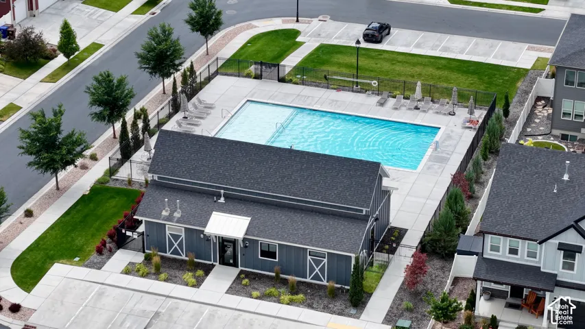 Outdoor swimming pool with surrounding patio, lounge chairs, and umbrella seating
