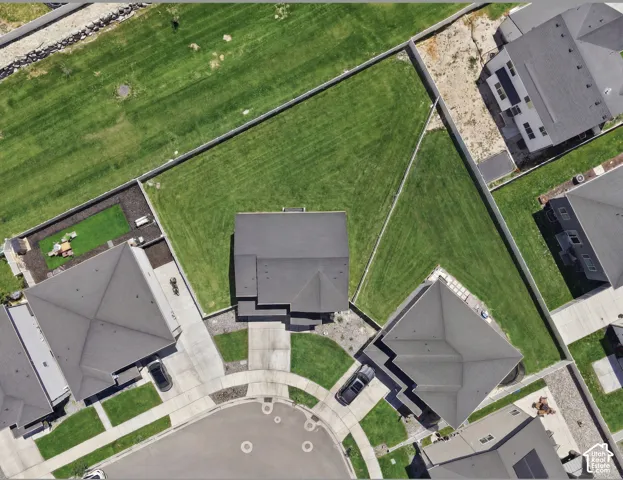 Expansive property featuring a cul-de-sac location, concrete driveway, and a large, fenced grass yard. Digitally enhanced to illustrate landscaping option.