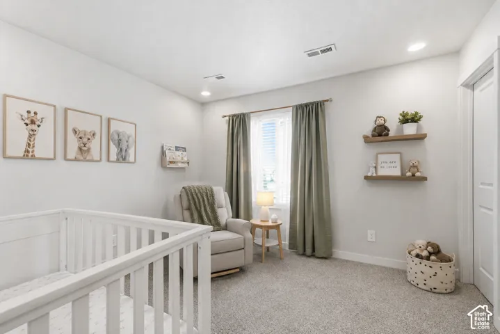 Well-lit room featuring light gray walls and plush gray carpeting