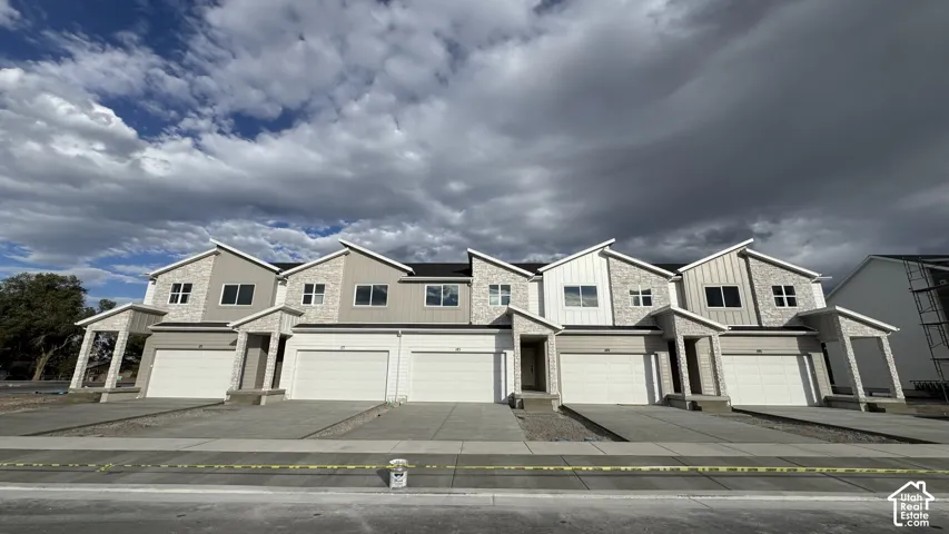 Modern townhomes featuring varied exterior finishes, attached garages, and a uniform architectural style