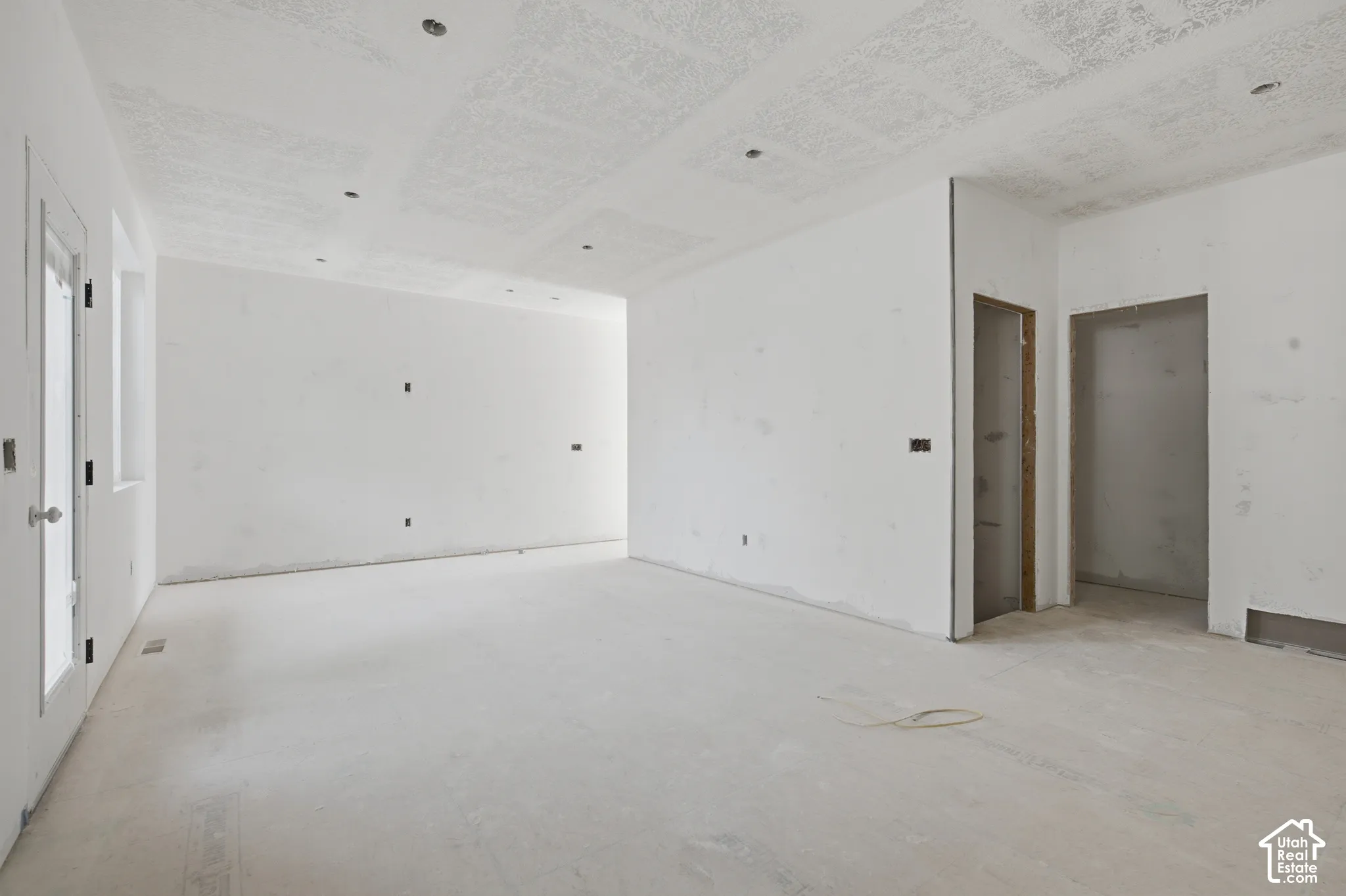 Expansive interior space with smooth white walls and recessed ceiling lights