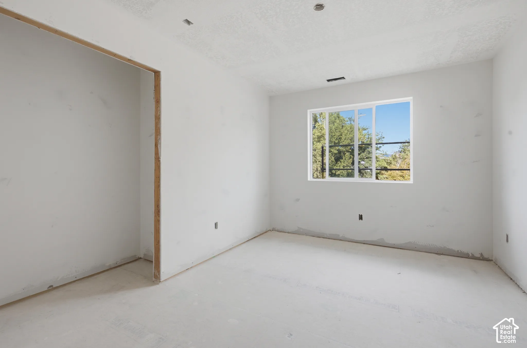 Large window providing natural light, recessed ceiling lighting, and a neutral color palette