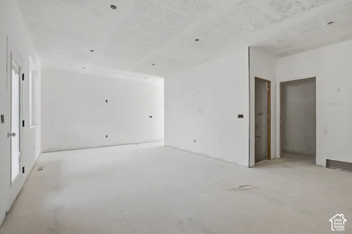Expansive interior space with smooth white walls and recessed ceiling lights