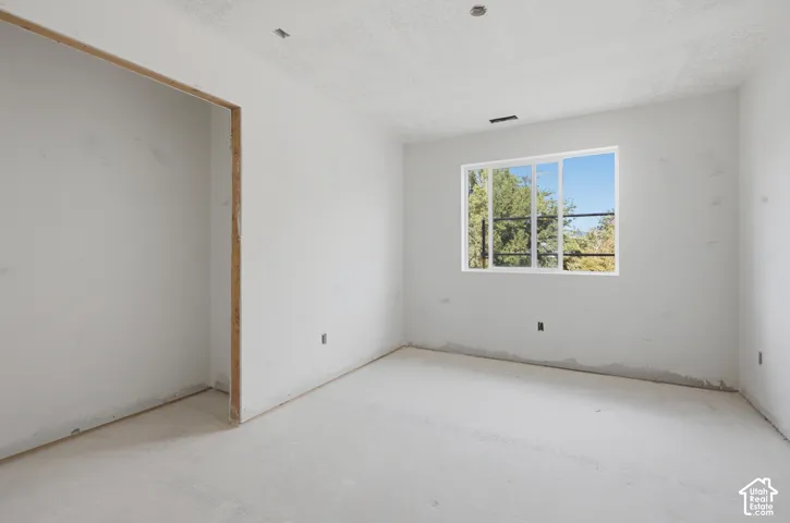 Large window providing natural light, recessed ceiling lighting, and a neutral color palette