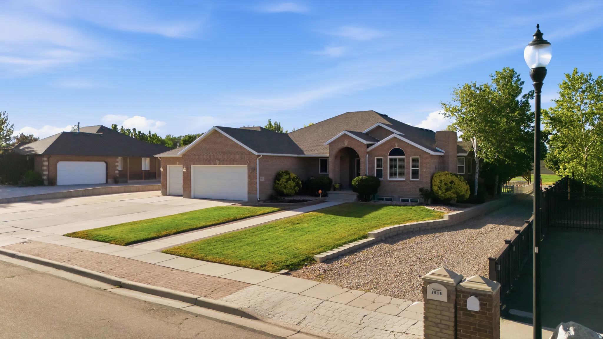 Brick facade residence featuring an arched entryway, multiple gables, and a two-car garage