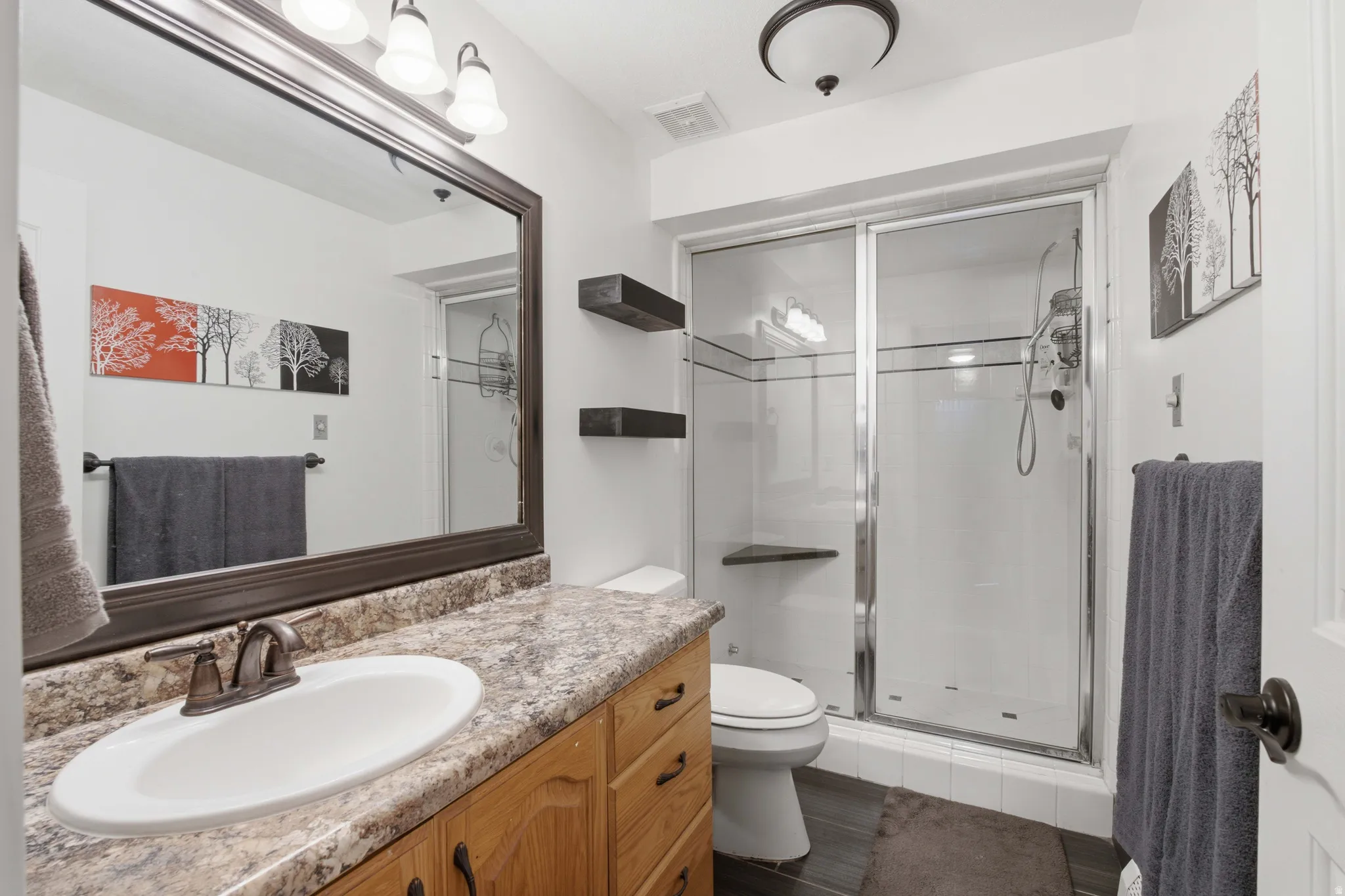 Bathroom featuring a wood vanity with an integrated sink, a speckled countertop, and an oil-rubbed bronze faucet