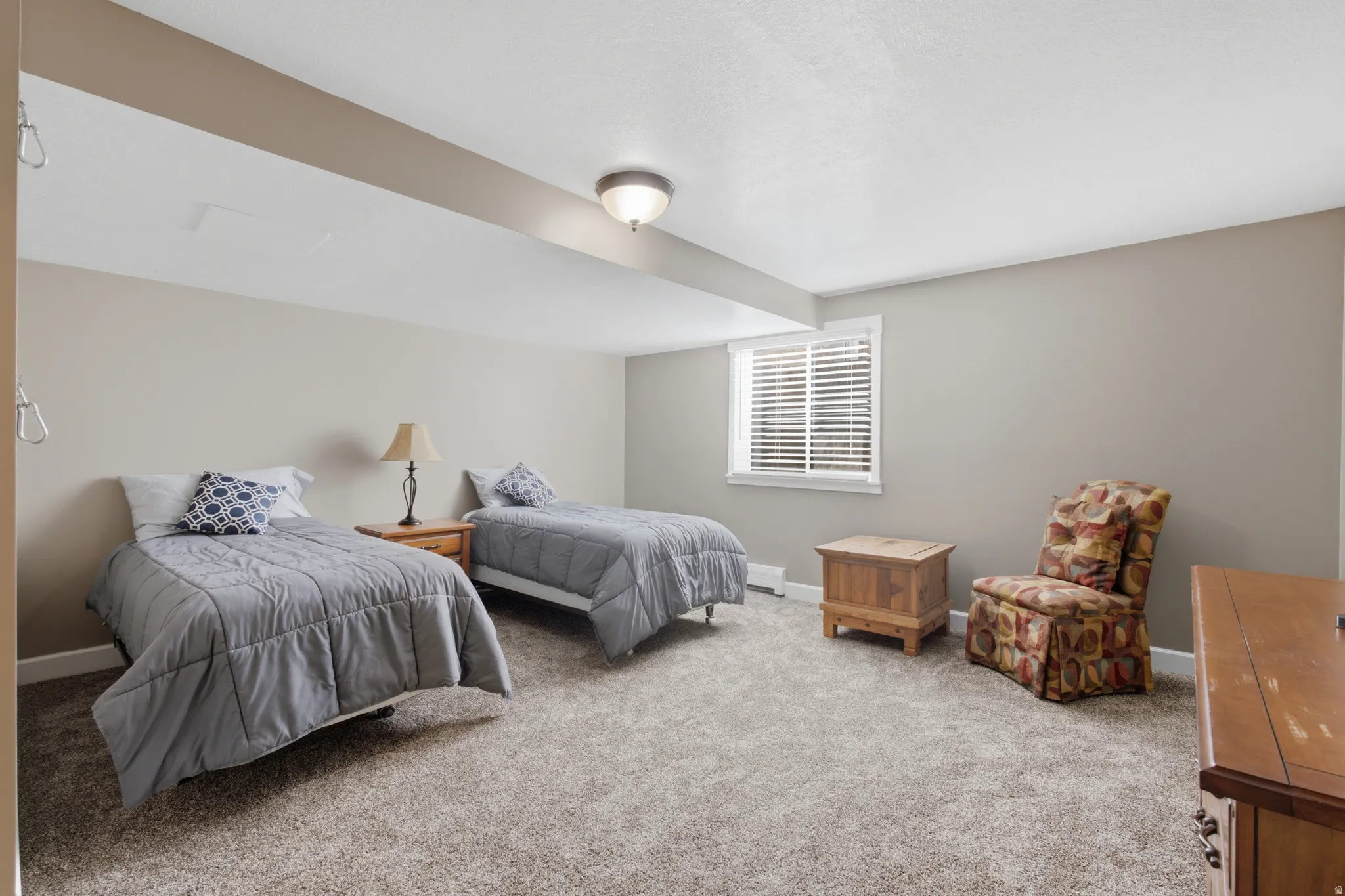 Carpeted room featuring neutral wall tones and a window with white blinds