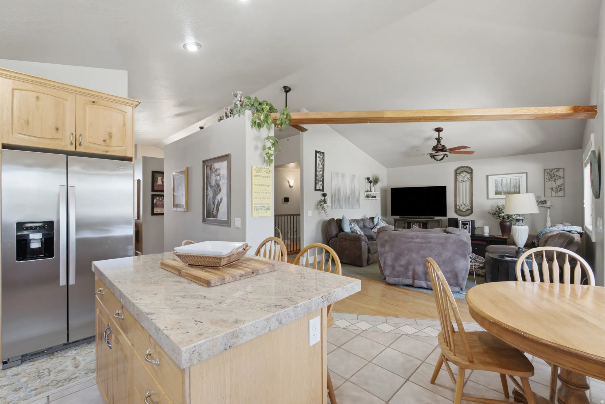 Kitchen island featuring a light-toned countertop and natural wood-finish cabinetry