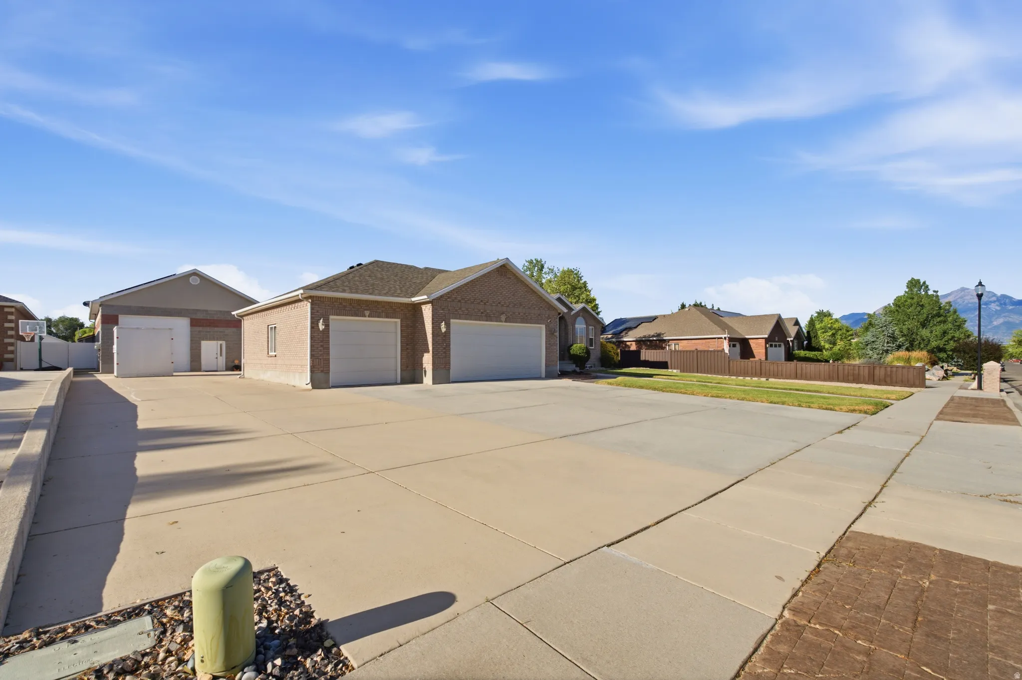 Expansive concrete driveway servicing a brick-front residence with multiple garage doors