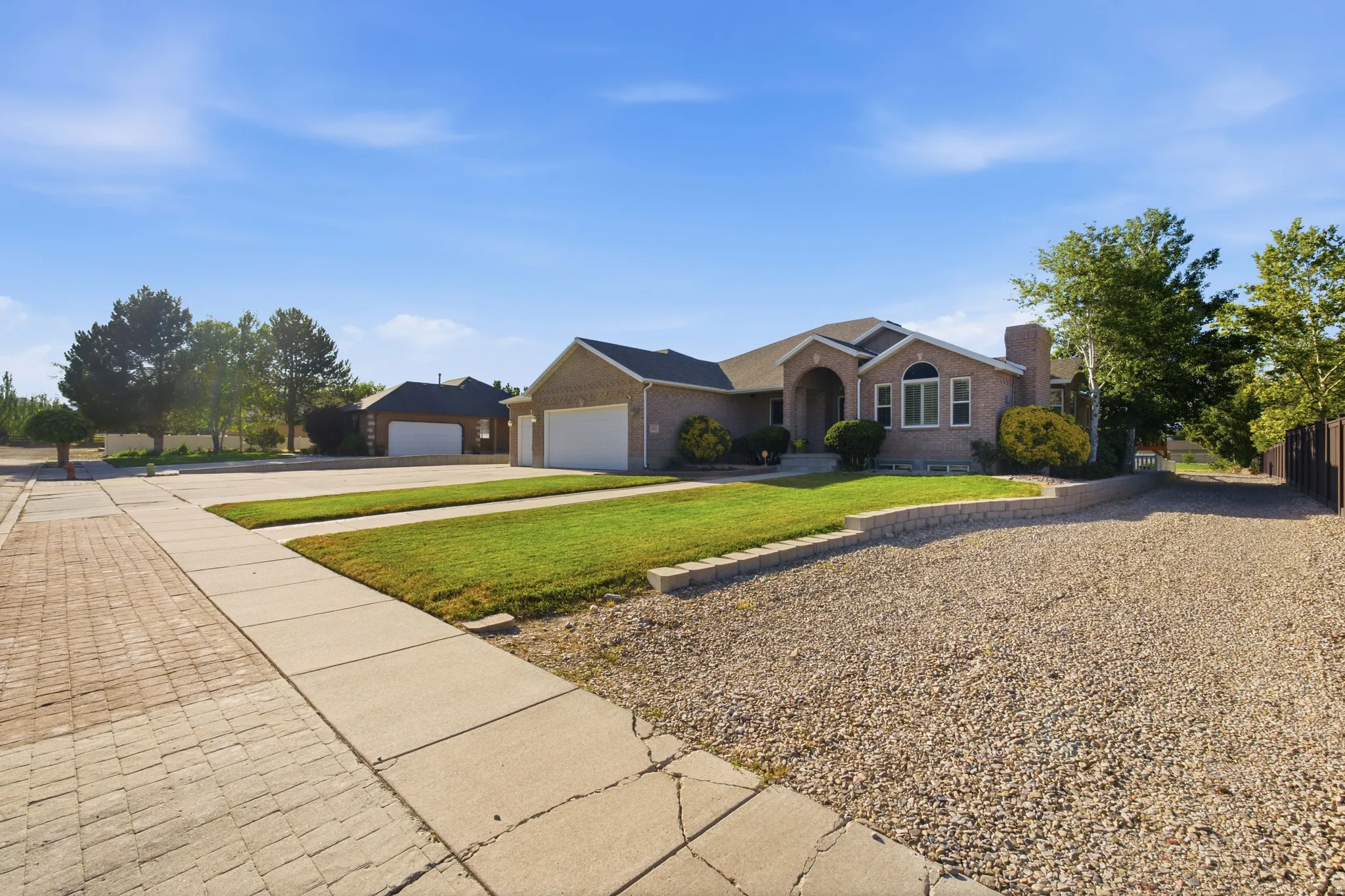 Brick exterior home featuring a curved entryway, arched windows, and an attached two-car garage
